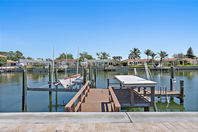 view of dock with a water view, a residential view, and boat lift