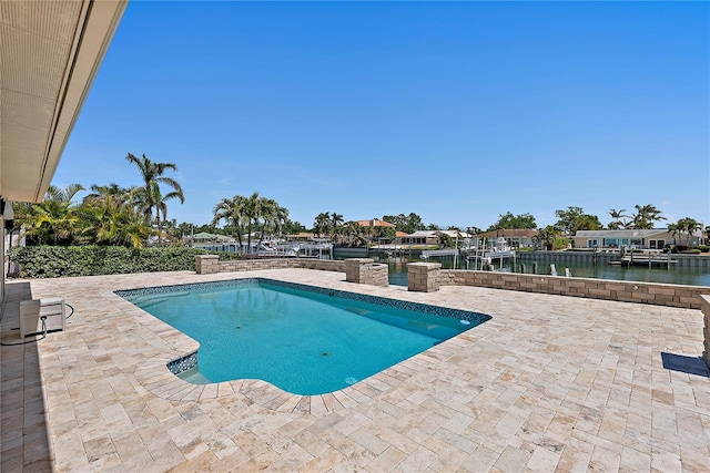 outdoor pool featuring a water view and a patio area