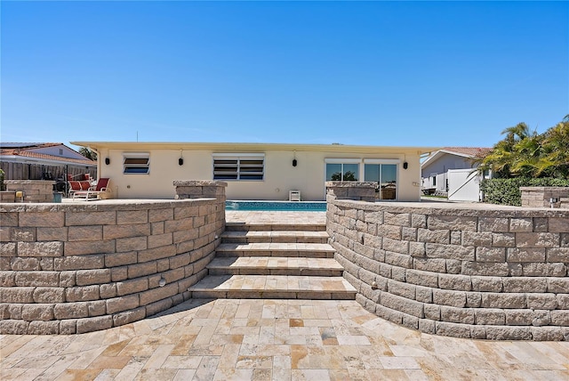 back of property with stucco siding, fence, and a patio area