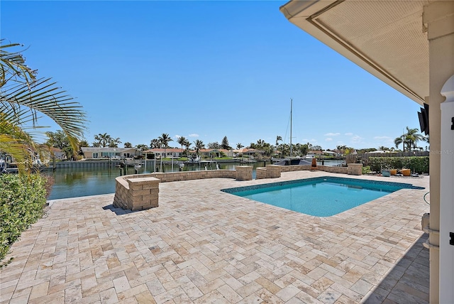 outdoor pool featuring a water view and a patio area