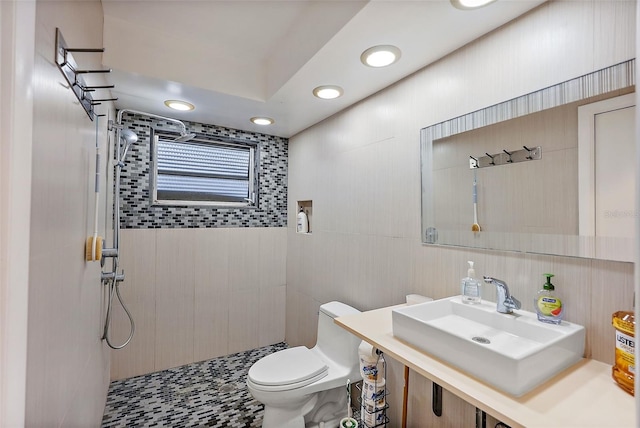 bathroom with toilet, a sink, and tiled shower