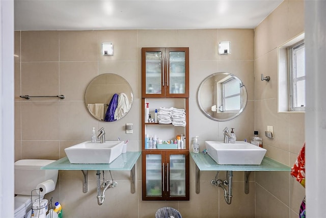 bathroom with a sink and tile walls