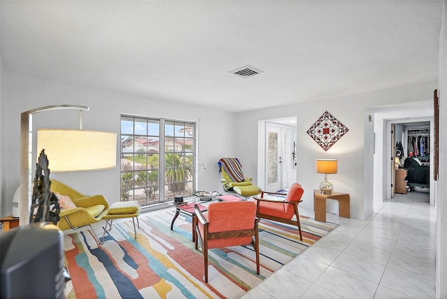 living room featuring arched walkways, visible vents, and tile patterned flooring