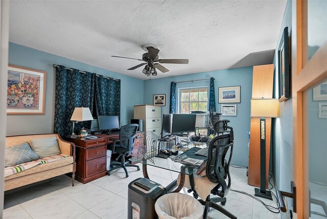 office space featuring ceiling fan, light tile patterned floors, and a textured ceiling