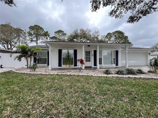 ranch-style home with a garage, concrete driveway, brick siding, and a front yard