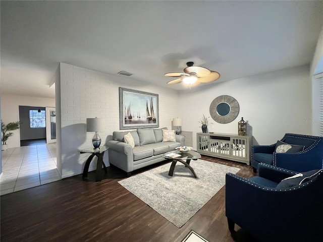 living room featuring dark wood-style floors, ceiling fan, and visible vents