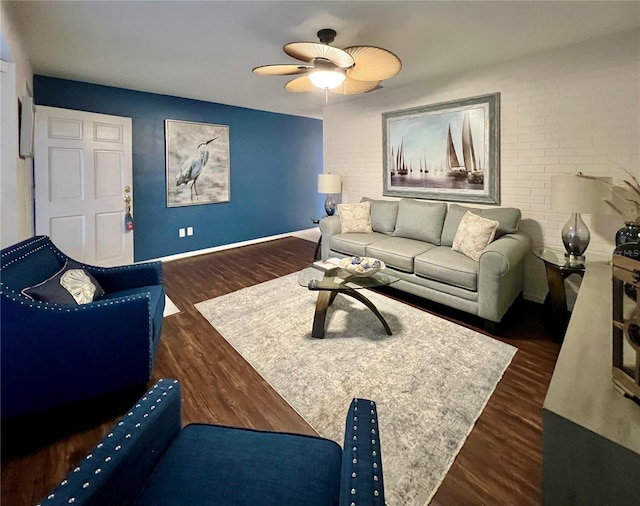 living room with dark wood finished floors, a ceiling fan, and baseboards