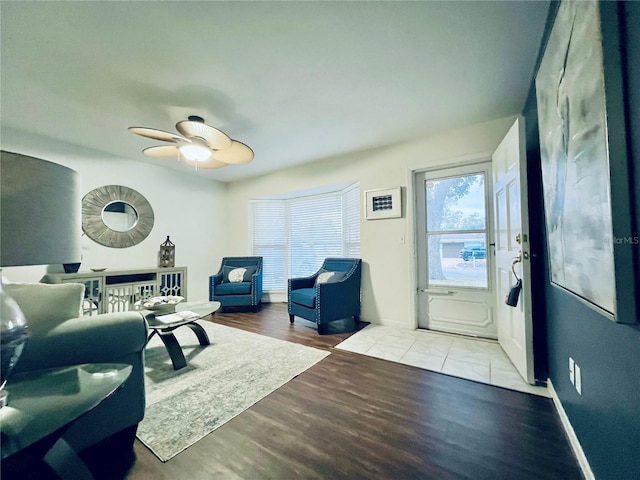 living room with light wood finished floors and a ceiling fan