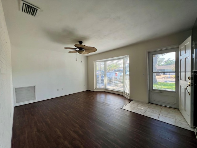 empty room with a ceiling fan, light wood-type flooring, visible vents, and baseboards