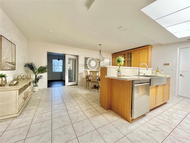 kitchen featuring light countertops, backsplash, dishwasher, an island with sink, and pendant lighting