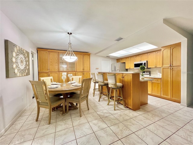 dining area featuring light tile patterned flooring, visible vents, and baseboards