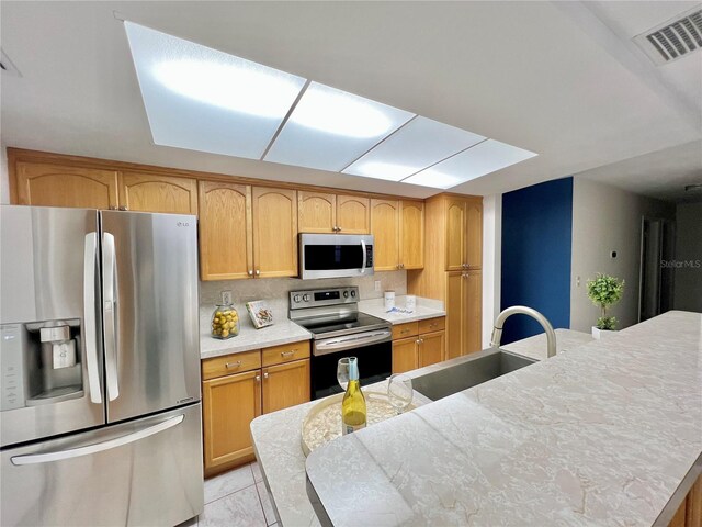 kitchen with a sink, visible vents, stainless steel appliances, and light countertops