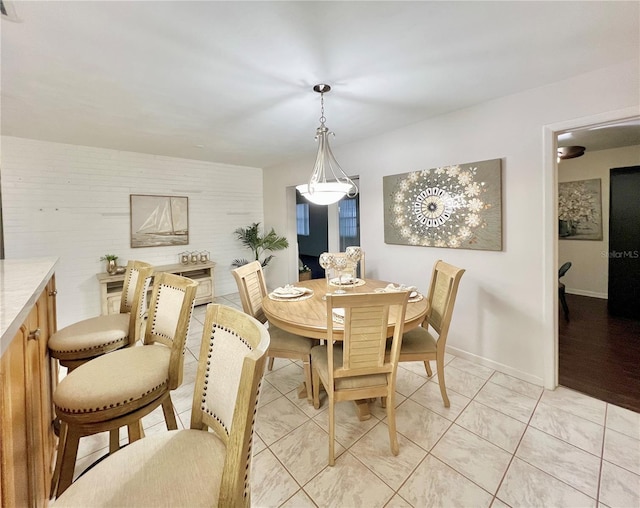 dining room featuring baseboards and light tile patterned floors