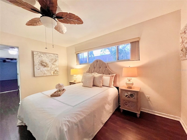 bedroom with dark wood-style floors, ceiling fan, and baseboards