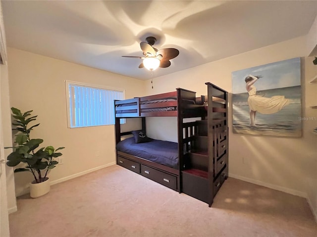 carpeted bedroom with ceiling fan and baseboards