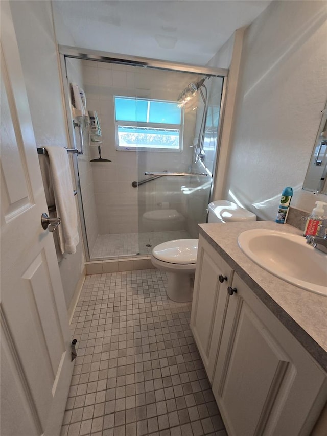 bathroom with vanity, tile patterned flooring, toilet, and walk in shower