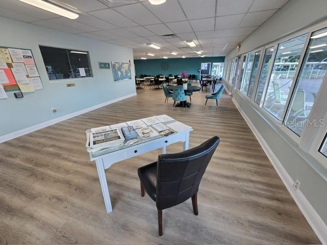 interior space with a paneled ceiling and wood-type flooring