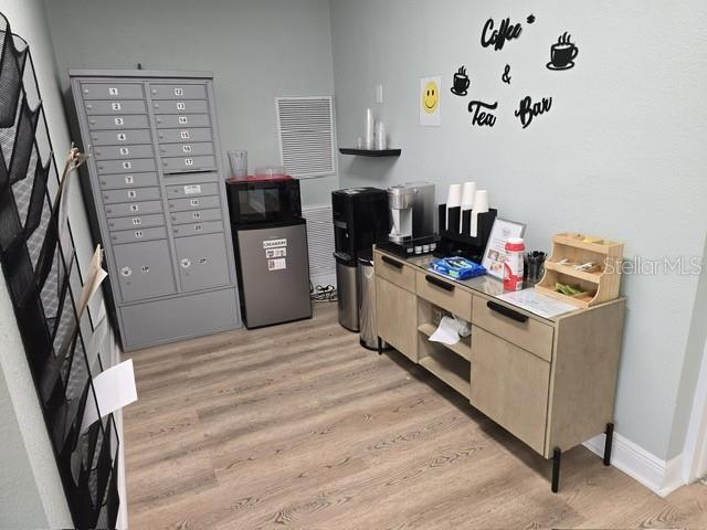 office area with light hardwood / wood-style flooring and a mail area