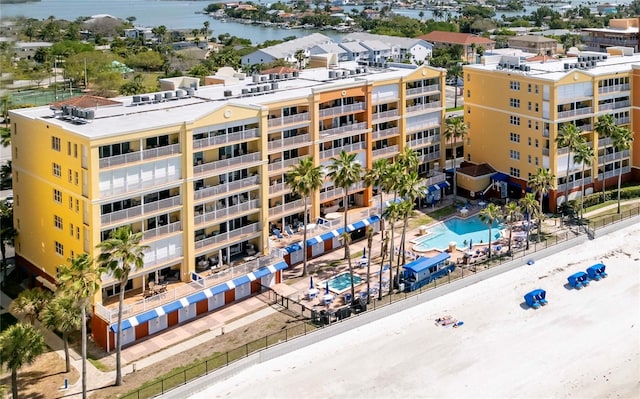 view of building exterior with a community pool and a water view