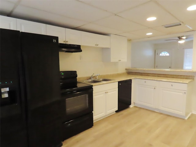 kitchen featuring light hardwood / wood-style flooring, white cabinetry, black appliances, and sink