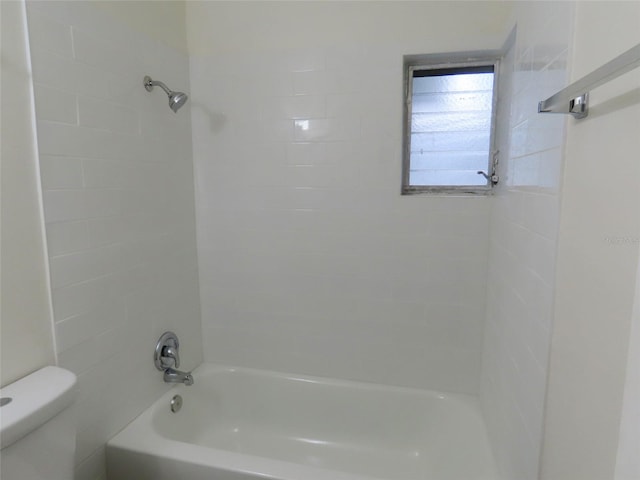 bathroom with tiled shower / bath combo and toilet