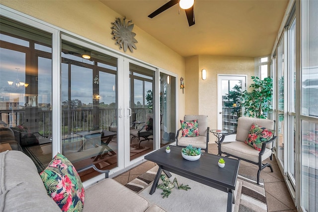 sunroom / solarium with ceiling fan with notable chandelier