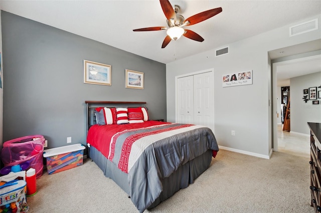 carpeted bedroom with ceiling fan and a closet