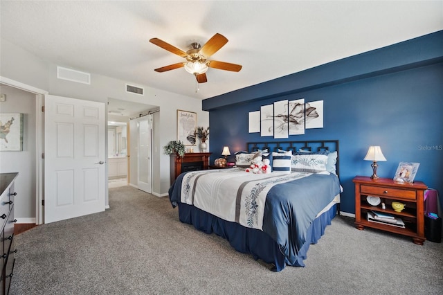 bedroom with carpet floors, ceiling fan, and connected bathroom