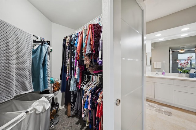 walk in closet featuring sink, ceiling fan, and light tile patterned floors