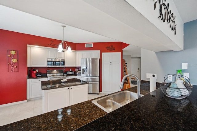 kitchen with light tile patterned flooring, white cabinetry, sink, appliances with stainless steel finishes, and pendant lighting