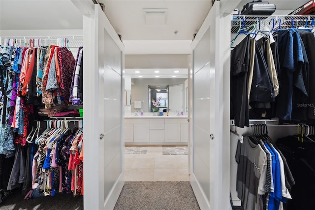 spacious closet featuring light tile patterned flooring and sink