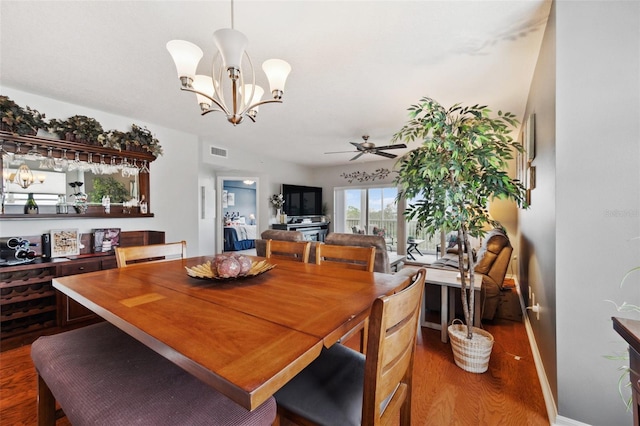 dining room featuring wood-type flooring and ceiling fan with notable chandelier