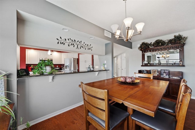 dining room with hardwood / wood-style floors and a notable chandelier