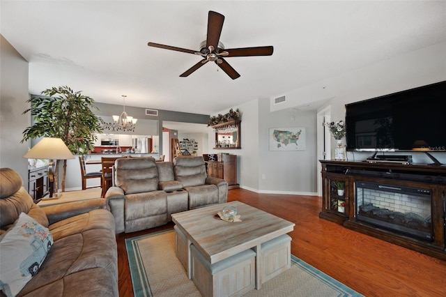 living room with hardwood / wood-style flooring and ceiling fan with notable chandelier