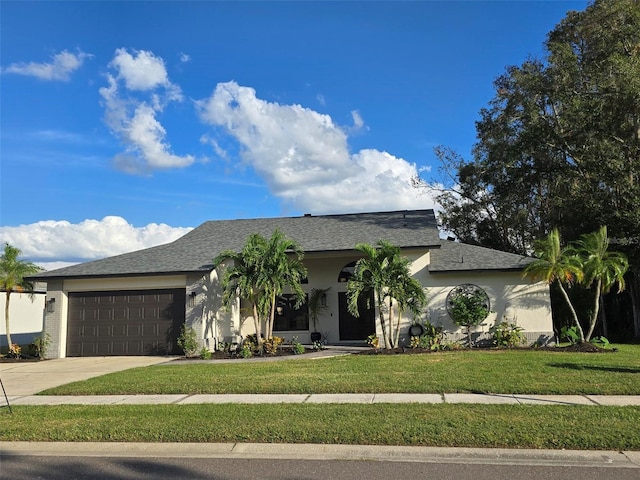 view of front of home with a garage and a front lawn