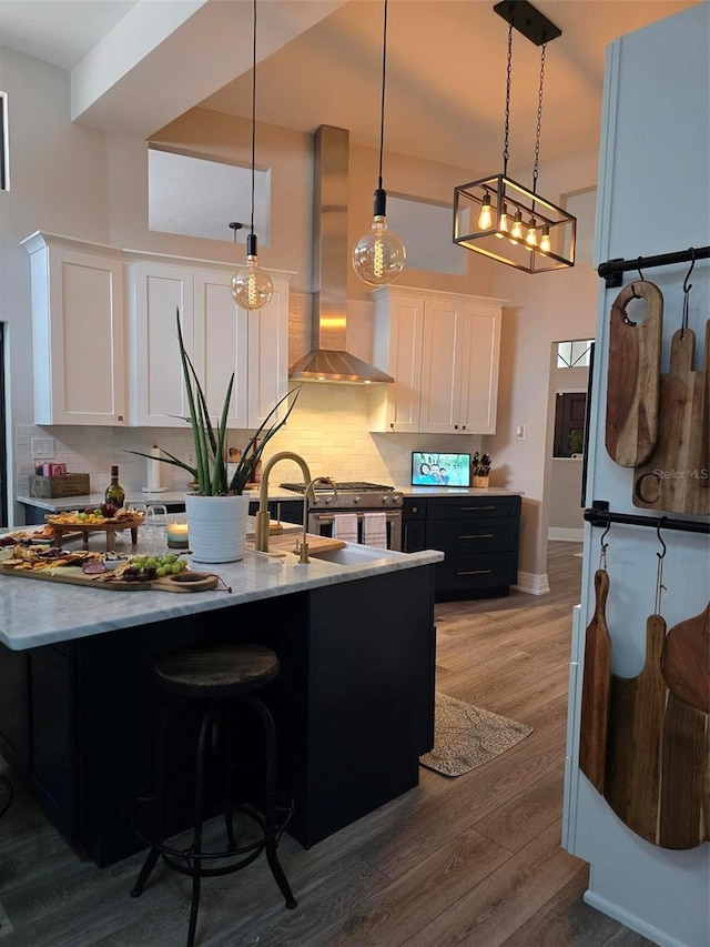 kitchen featuring white cabinetry, wall chimney exhaust hood, decorative backsplash, and pendant lighting