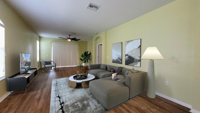 living room featuring ceiling fan and dark hardwood / wood-style flooring