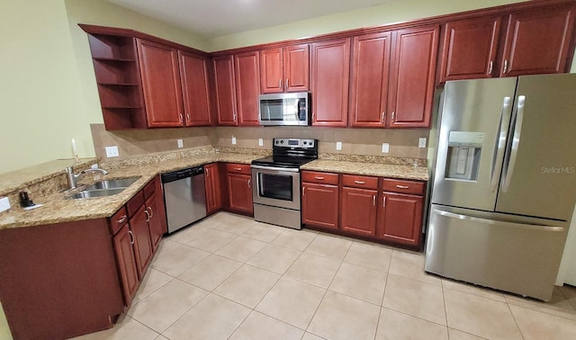 kitchen featuring light tile patterned floors, sink, light stone counters, and appliances with stainless steel finishes