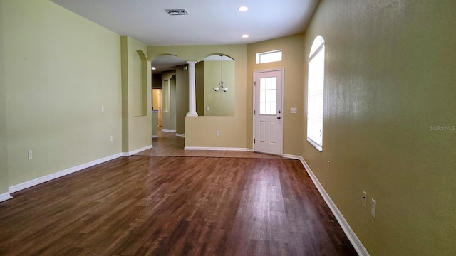 entrance foyer featuring hardwood / wood-style floors and ornate columns