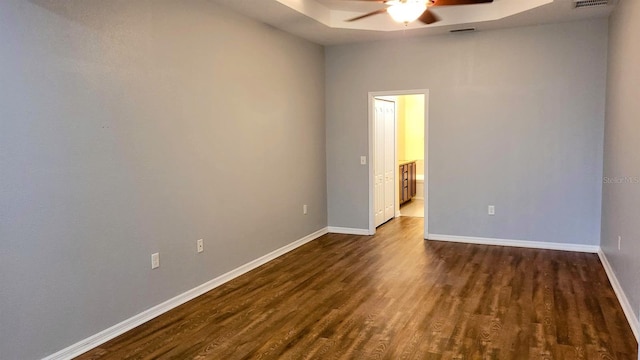 empty room with ceiling fan and dark hardwood / wood-style flooring