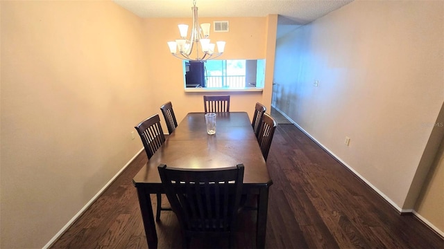 dining room with dark wood-type flooring and an inviting chandelier