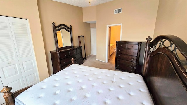 bedroom with light colored carpet, a textured ceiling, and a closet