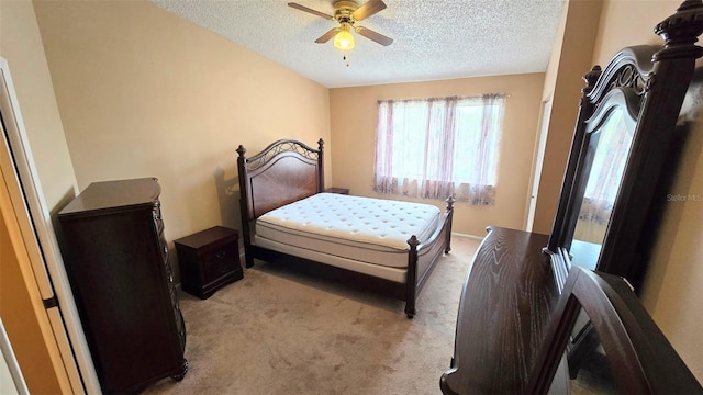 bedroom with ceiling fan, light carpet, and a textured ceiling