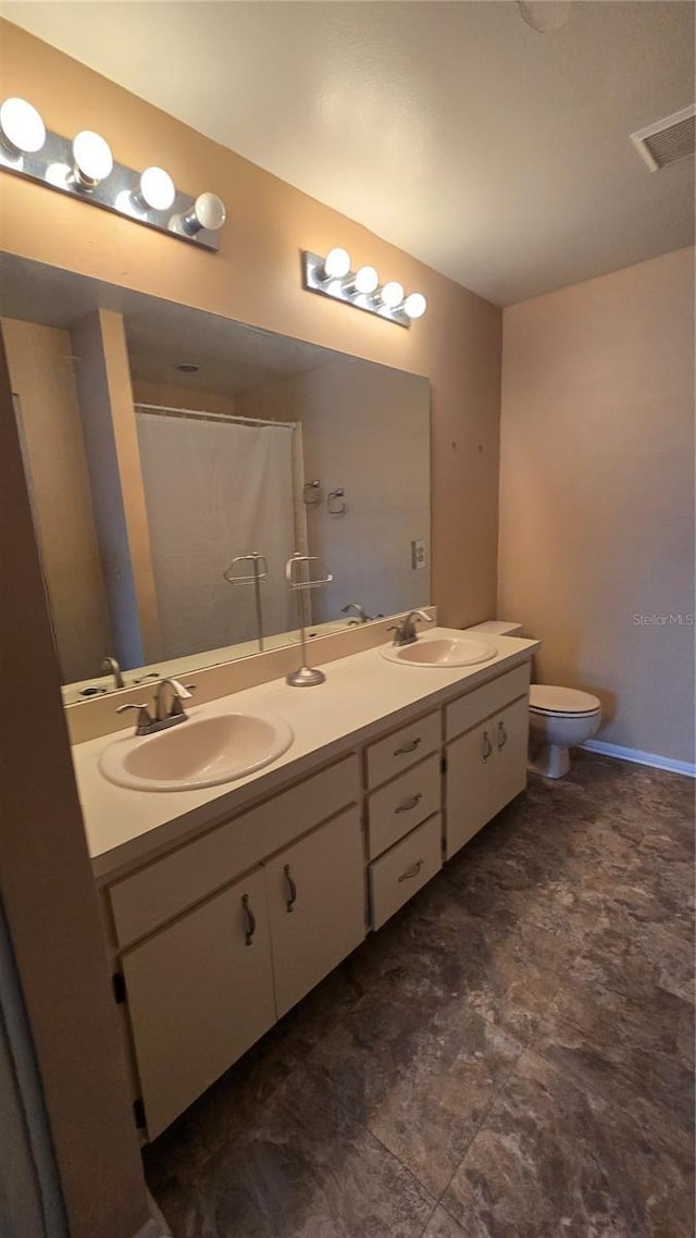 bathroom with walk in shower, vanity, and toilet