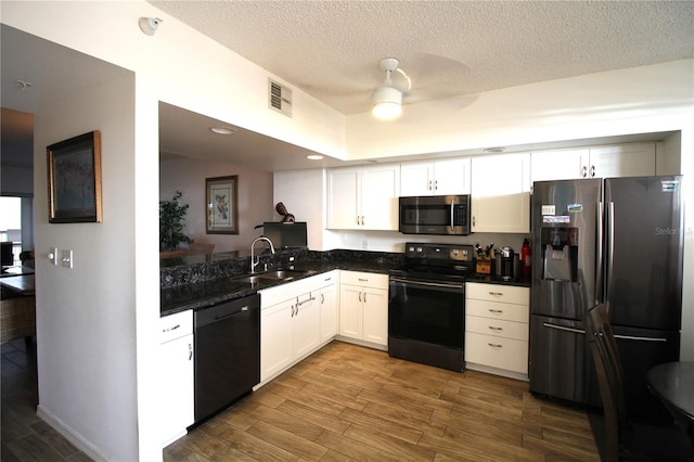 kitchen with white cabinets, hardwood / wood-style floors, black appliances, a textured ceiling, and sink