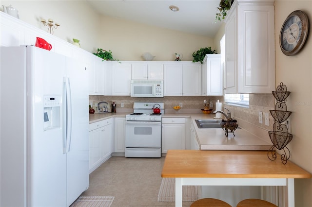 24617 Laurel Ridge Dr, Lutz, FL 33559 - kitchen with white appliances, a sink, backsplash, vaulted ceiling, and light countertops
