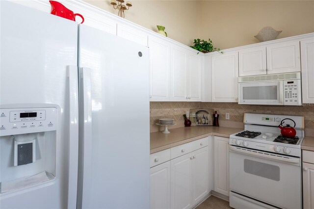 24617 Laurel Ridge Dr, Lutz, FL 33559 - kitchen with white appliances, decorative backsplash, light countertops, and white cabinetry