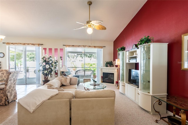 tiled living room featuring lofted ceiling, ceiling fan, and plenty of natural light