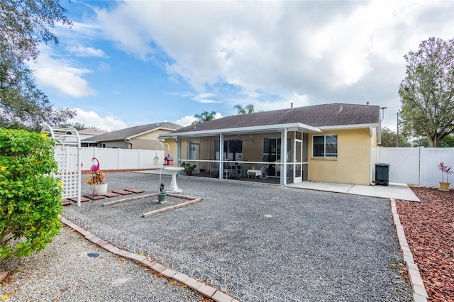 24617 Laurel Ridge Dr, Lutz, FL 33559 - back of house with a sunroom, a patio, a fenced backyard, stucco siding, and roof with shingles