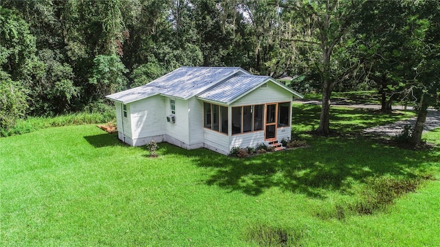 exterior space with a sunroom and a lawn